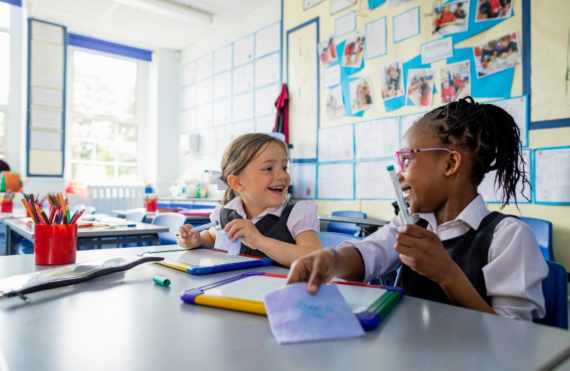 Young children smiling inside a classroom