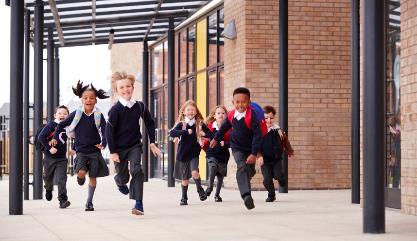 School children running in uniform and carrying school bags